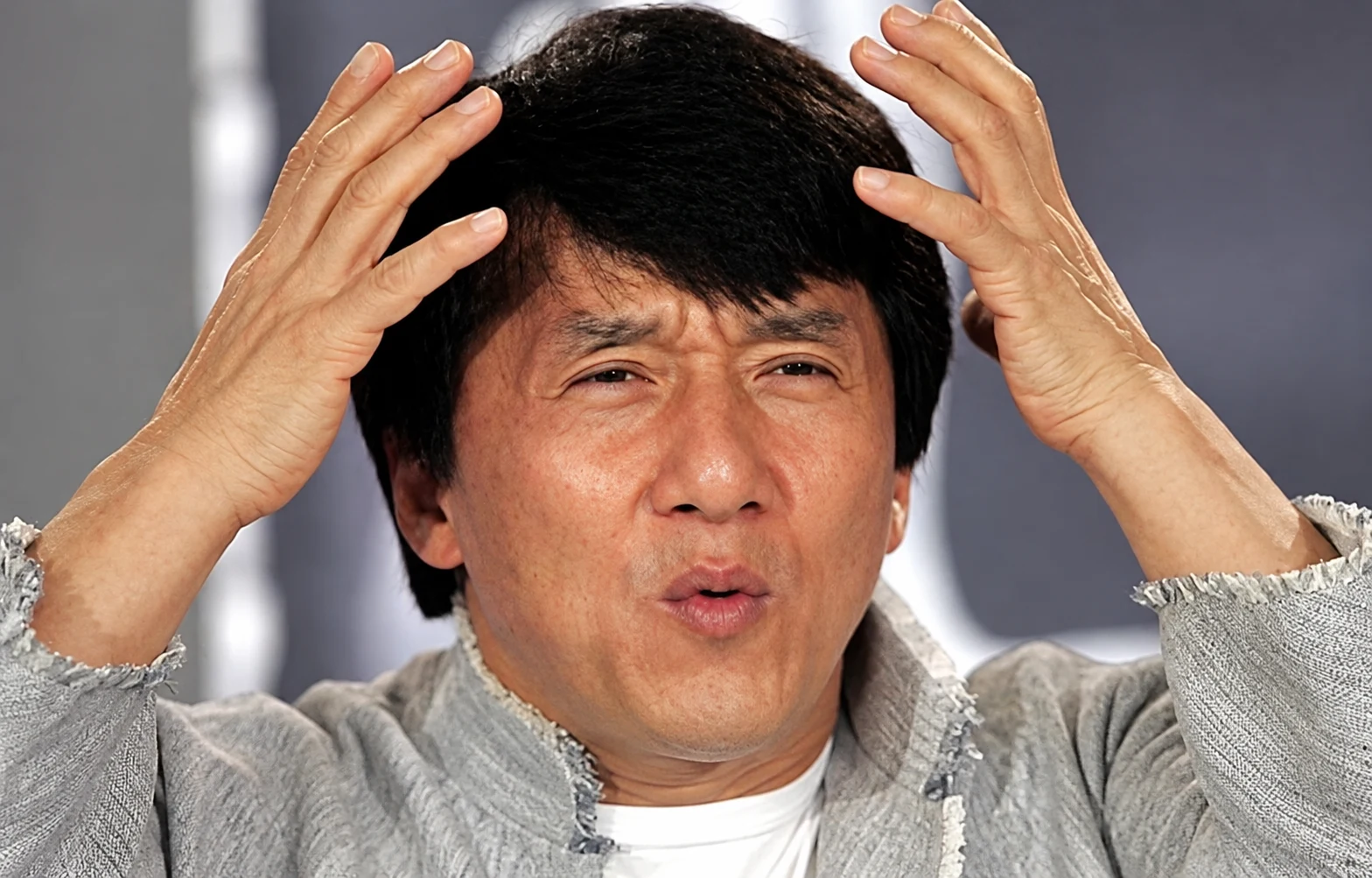 A man holding his head, confused