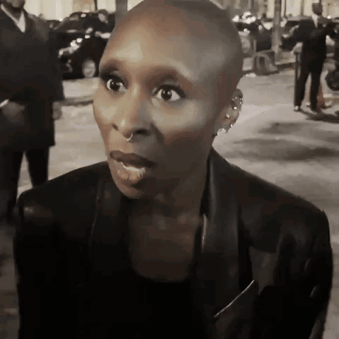A woman on a night street staring at the camera in disbelief